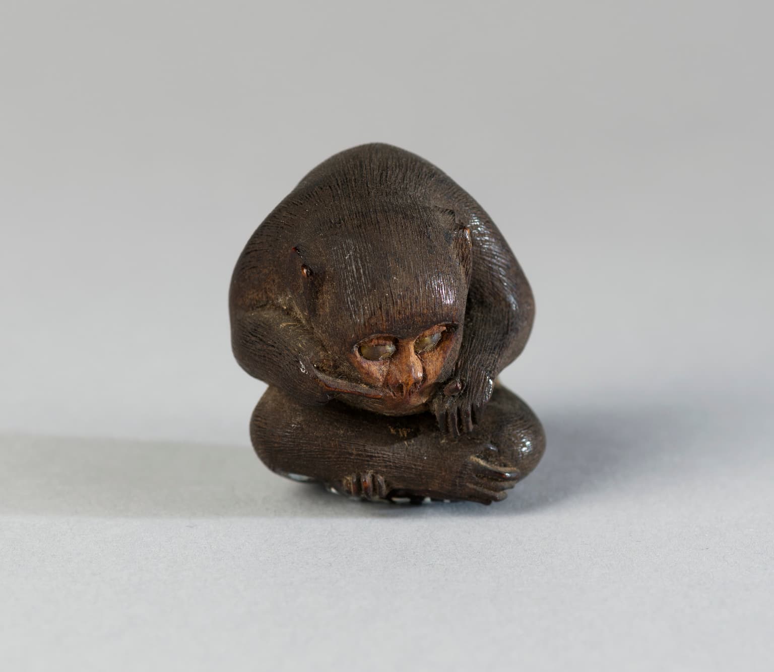 Houten okimono voorstellende een zittende aap #1